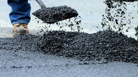 Man Scooping Asphalt